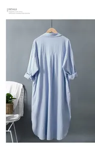 Vue arrière d'une robe chemise ample en coton et lin bleu clair sur un cintre en bois.