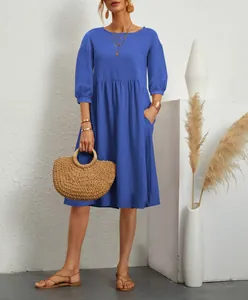 Fashionable blue cotton-linen dress with pleated waist and pockets on a model