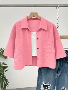 Close-up view of pink textured short sleeve button-down shirt showing fabric detail and pocket