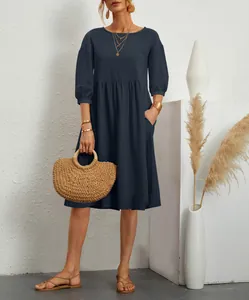 Macro view of navy blue pleated cotton linen dress with lantern sleeves and side pockets.