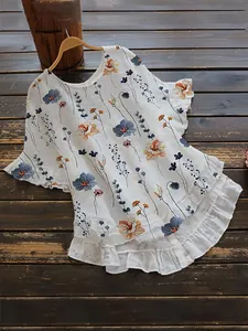 Vue détaillée d'une élégante blouse à fleurs avec manches volantées et ourlet étagé