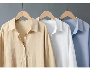 Chemises amples en coton et lin à manches longues en beige blanc et bleu sur des cintres