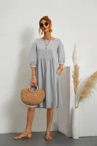 Close-up of a light blue pleated linen dress featuring lantern sleeves and side pockets