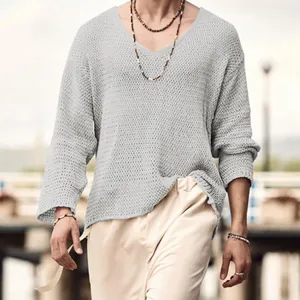 Detailed view of a men's light grey hollow-out knit sweater with a relaxed V-neck line