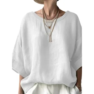 Close-up view of a white loose-fit linen blouse featuring a round neck and drop shoulders