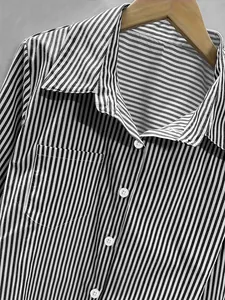 Detail of black and white vertical striped shirt showing buttons and pocket texture