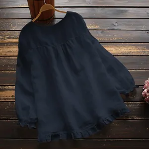 Detalle de una blusa de algodón y lino azul marino con dobladillo de volantes y puños elásticos.