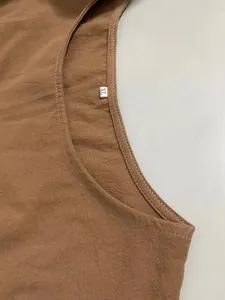Macro view of brown cotton linen dress neckline showing textured fabric and white XL size label