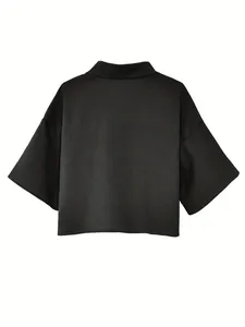 Detailed back view of a minimalist black cropped shirt featuring unique textured fabric.