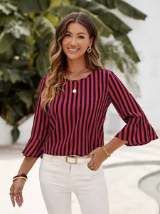 Detail view of woman wearing a red and navy vertical striped blouse with bell sleeves