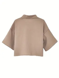 Detailed back view of a minimalist beige cropped shirt featuring wide mid-length sleeves