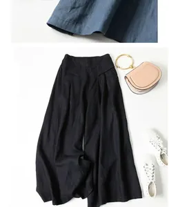 Detail of loose linen wide-leg culottes with high elastic waist on white background