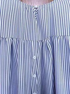 Gros plan d'une chemise à rayures bleues et blanches montrant la texture du tissu et boutons.