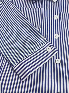 Detailed close-up showing blue and white striped fabric and buttons on a women's shirt