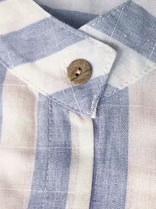 Gros plan d'un col de chemise à rayures bleues et blanches avec un bouton en bois décoratif