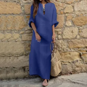 Vestido largo azul con cuello en V y bolsillos en un entorno exterior informal
