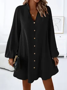 Detail of black V-neck A-line dress showing the button-down front and long sleeve cuffs.