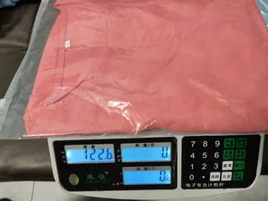 Detailweergave van een roze katoenen linnen blouse op een digitale weegschaal van 123g.