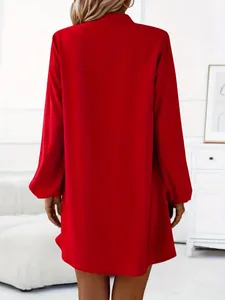 Back view of a vibrant red long-sleeve A-line mini dress shown in a bright interior.