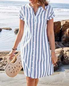 Stylish blue and white vertical striped loose summer shirt dress shown in beach scenery