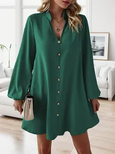 Detail view of a solid emerald green V-neck long sleeve button-down A-line mini dress