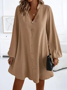 Close-up detail of women's camel long-sleeve V-neck single-breasted A-line dress