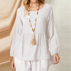Detailed view of white babydoll blouse with lantern sleeves and textured fabric