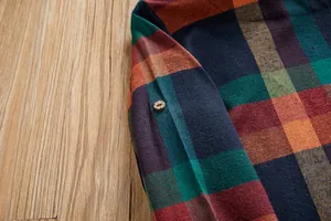 Vue détaillée de la manche d'une chemise à carreaux avec patte à bouton en bois