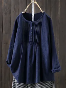 Close-up of pleated navy blue linen shirt showing fabric texture and detail