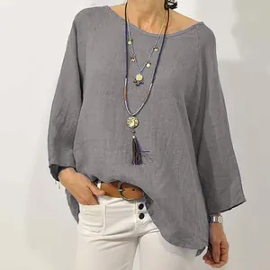 Dettaglio di una camicetta grigia in cotone e lino con scollo tondo e maniche raglan.