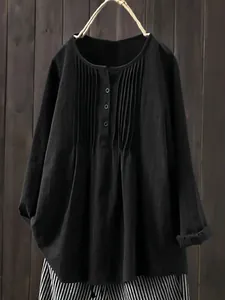 Close-up of black linen cotton shirt featuring elegant chest pleats and button neckline detail