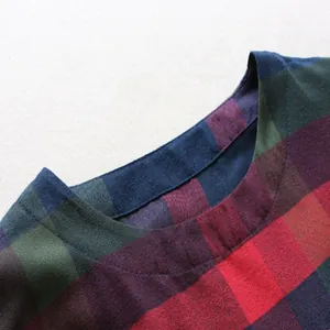 Détail rapproché du col rond d'une chemise à carreaux rouge et bleu marine classique