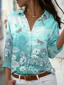 Macro view of elegant floral and butterfly patterns on a turquoise long sleeve shirt