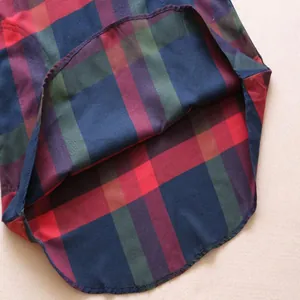 Détail en gros plan du motif classique à carreaux rouges et bleus sur l'ourlet de la chemise.