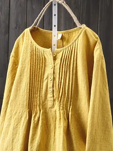 Detailed view of yellow slub cotton linen shirt with pleated front and buttons