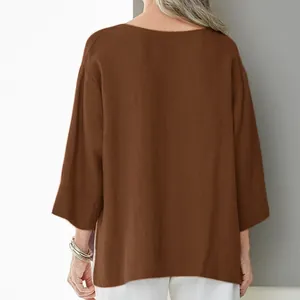 Detailed back view of a brown loose cotton linen blouse with 3/4 sleeves and side slits