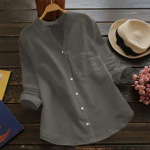 Détail d'une chemise en coton gris foncé à manches longues sur un fond en bois rustique.