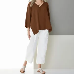 Fashionable brown V-neck cotton linen blouse with side slits and white wide-leg pants