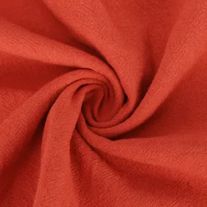 Close-up macro detail showing the soft red cotton-linen shirt fabric texture and weave