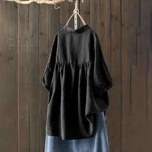 Detailed macro view of the pleated waistline on this black stand collar cotton blouse