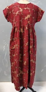 Detailansicht eines roten Baumwoll-Leinen-Kleides mit Blumenmuster und Rundhalsausschnitt