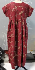 Detalle de un vestido rojo de algodón y lino con estampado floral, cuello redondo y holgado