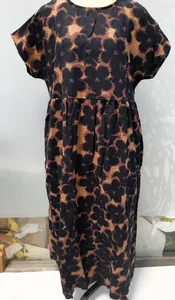 Vista detallada del estampado floral oscuro y la cintura suelta de este vestido de lino.
