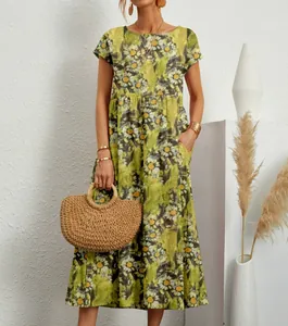 Detailansicht eines grünen Damen-Maxikleids aus Baumwollleinen mit Blumenmuster und Taschen