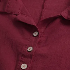 Détail d'une chemise rouge en coton et lin avec un col à revers classique et des boutons en bois