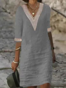 Close-up detail showing the elegant V-neckline and lace trim on a grey linen dress