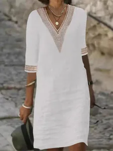 Detail of a white V-neck cotton linen dress featuring intricate lace trim on sleeves