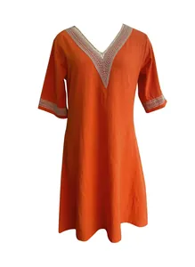 Detail view of an orange V-neck linen dress featuring intricate white lace trim.