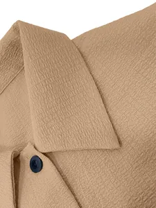 Macro view of tan women's casual shirt showing seersucker fabric texture and button detail