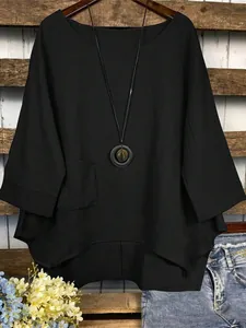 Détail d'un chemisier noir surdimensionné en coton et lin avec ourlet asymétrique